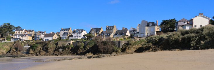 Houses on the cliff from sand Beach of Lancieux, France during low tide