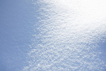 Powdery white fluffy snow close-up. White clean snow texture. Winter background. Selective focus.