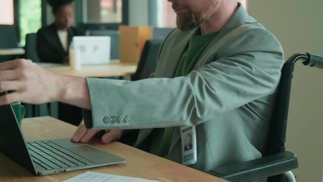 Wheelchaired man beginning workday at office