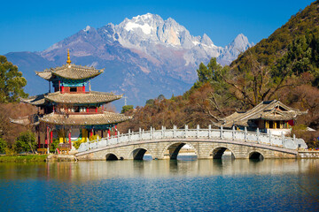 Bridge and pagoda pavilion at the Black Dragon Pool with Yulong Snow Mountain in the background....
