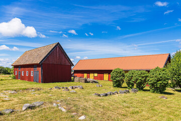 Rote Holzhäuser und Bäume auf der Insel Sladö in Schweden