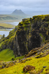 Inland view from Dyrholaey to the rugged green hills and lagoons of southern coastal Iceland.