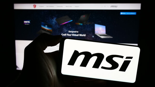 Stuttgart, Germany - 02-24-2024: Person holding mobile phone with logo of Taiwanese company Micro-Star International Co. Ltd. (MSI) in front of web page. Focus on phone display.