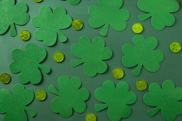 St. Patrick's day pattern with clover leaves and green coins on green background. Flat lay. View...