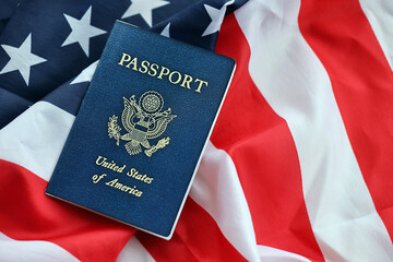 Fototapeta premium Blue United States of America passport on national flag background close up. Tourism and citizenship concept