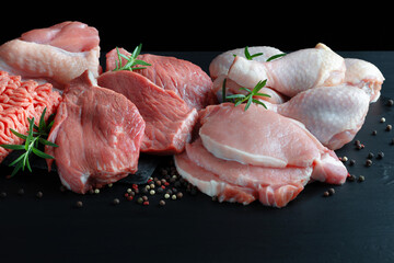Different types of raw meat - beef, pork, lamb, chicken on a wooden board