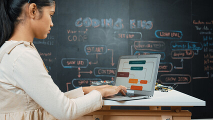 Highschool girl writing code or engineering prompt while attend in STEM technology class. Teenager...