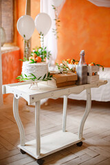 Serving Table in Orange Room with White Cake with Cream and Fresh Tangerines.