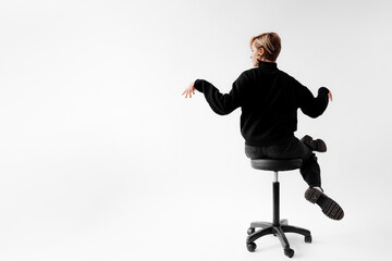 A dynamic shot capturing a professional from behind in mid-movement, perched on an office stool