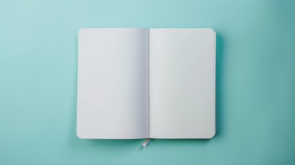 A white blank notebook is open and lying flat on a mint blue background. The notebook appears empty. Mockup with copy-space, place for text, top view, flat lay.