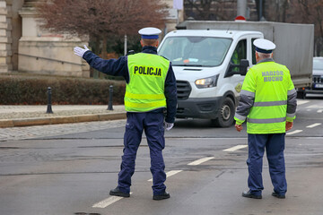 Policjant ruchu drogowego zatrzymuje pojazd na ulicy. - obrazy, fototapety, plakaty