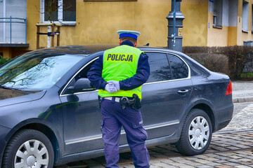 Policjant ruchu drogowego zatrzymuje pojazd na ulicy.