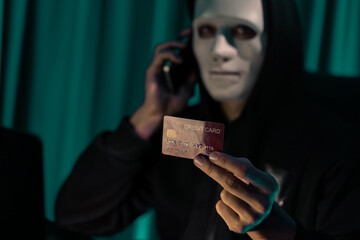 White criminal anonymous mask calling to credit card owner to threaten ransom with privacy information all database, making password encryption by programming hack trying to make insecure. Pecuniary.
