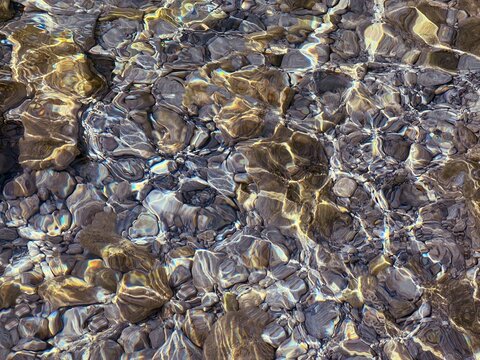 Pebbles and stones in the clear water at the bottom of sea.