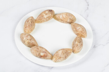 Cold appetizer. Jellied meat in the shape of a quenelle. On a plate.  White background. Close up