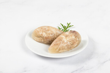 Cold appetizer. Chicken jellied meat in the shape of a quenelle. On a plate. Close up