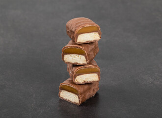 Vegan dessert snack. Cookies with caramel in chocolate glaze. In the section. Dark background. Close-up