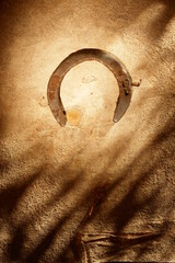 A rusty horseshoe is on a wall - 748990734