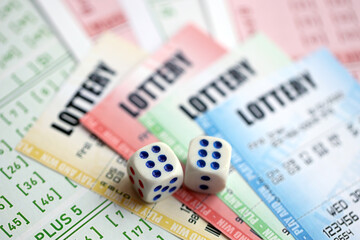Lottery tickets of different colors and dice on blank bills with numbers for playing lottery close...