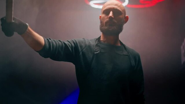 bald brazen robber with a beard holding a hammer during robbery attack crimes threats