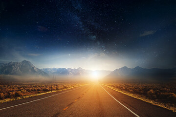 Picturesque landscape scene and sunrise above road .A long straight road leads to a mountain with...