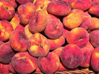 Flat peach fruits in the basket. 