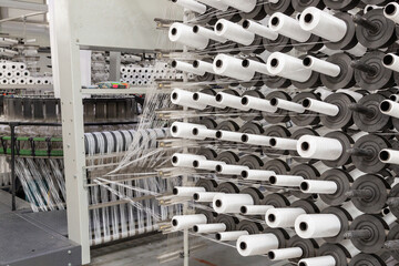 Factory equipment in perspective. Rows with coils of polypropylene threads for weaving cloth....