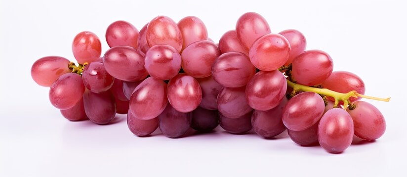 A cluster of ripe grapes is positioned on a clean white table, showcasing their vibrant colors and inviting freshness. The contrast between the deep purple grapes and the pristine white surface