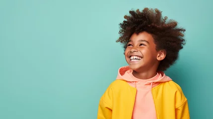 Fotobehang Kind lachend mit guter Laune und positiver Ausstrahlung vor farbigem Hintergrund in 16:9  © Laura