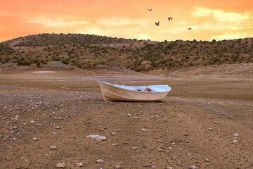 White small boat that remained above the ground as the lake dried up. It's drought time. amazing...