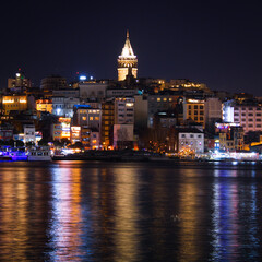 Fototapeta premium Reflection of Istanbul Galata Tower and buildings on the sea 