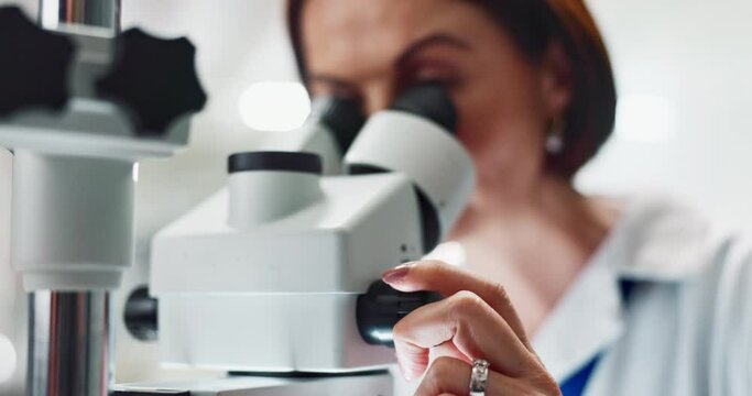 Woman, scientist and forensic research with microscope for science, microbiology or discovery at laboratory. Closeup of person or researcher looking in scope or lens for scientific breakthrough test