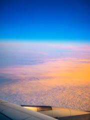 Fototapeta na wymiar Cloudscape and blue sky at sunset, a view through the airplane window over Seoul Incheon International Airport, South Korea, a tranquil high altitude scenery