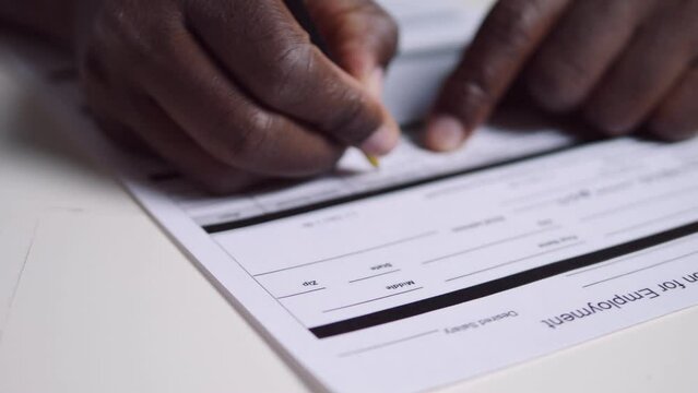 working abroad - black man fills out the application form for employment