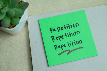 Concept of Repetition, Repetition, Repetition write on sticky notes isolated on Wooden Table.