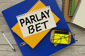 PARLAY BET text on the page. yellow notepad on blue folder