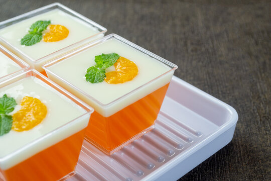 pudding jeruk vla susu or orange pudding topped with milk vla sauce, orange slices and mint leaves. Very fresh and healthy