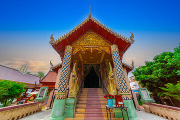 Fototapeta premium Beautiful Wat Buddhist temples in Chiangmai Chiang mai Thailand. Decorated in beautiful ornate colours of red and Gold and Blue. Lovely sunset