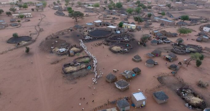 Aerial fly over.  A typical farming village in the barren landscape of the Sahel region, Sahara Desert, Senegal. Drought, Climate Change, Desertification