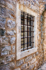 Ancient window with bars in a stone castle
