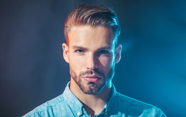Man portrait. Serious fashionable bearded man in denim shirt. Sexy handsome male model with beard...
