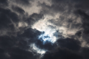A partial solar eclipse of October 25, 2022 captured through moody dark clouds, the maximal phase visible from Europe, Romania