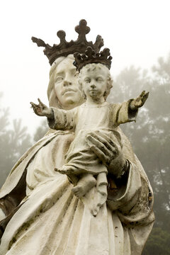 Estátua de santa com filho na mão.  