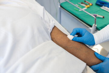 A healthcare professional is preparing a patient's arm for a procedure