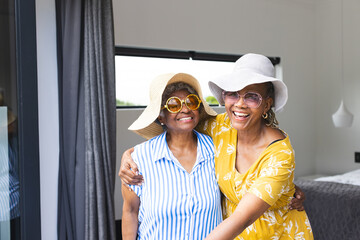 Senior African American woman and senior biracial woman share a joyful embrace on vacation