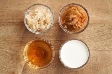 Fermented foods in glass bowls - kimchi, sauerkraut, apple cider vinegar and kefir