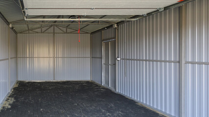 Interior of new empty iron garage, textured surface road tile on ground, Film grain effect