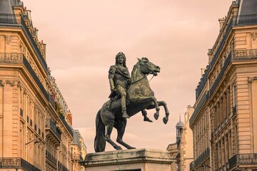 Ancienne statue du roi Louis XIV à Paris avec effet d'ambiance coucher de soleil - obrazy, fototapety, plakaty
