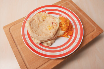 cheese pupusas on a rustic plate, complemented by vibrant curtido, emblematic of El Salvador's culinary heritage