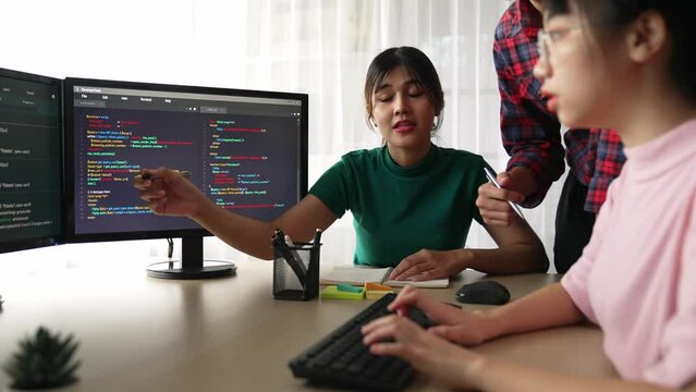 Slow motion back end software developer engineer for computer programming working together on debugging writing computing code, solving complex algorithms display on monitor in office. Burgeoning